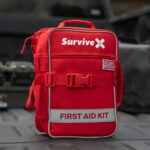SurviveX Large range first aid kit opened flat showing labeled, color-coded compartments
